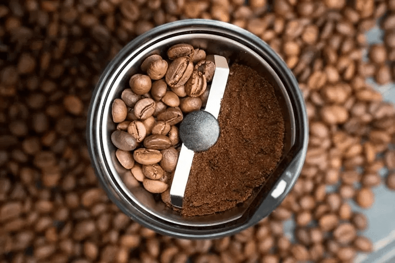 coffee grinder with coffee beans and ground coffee